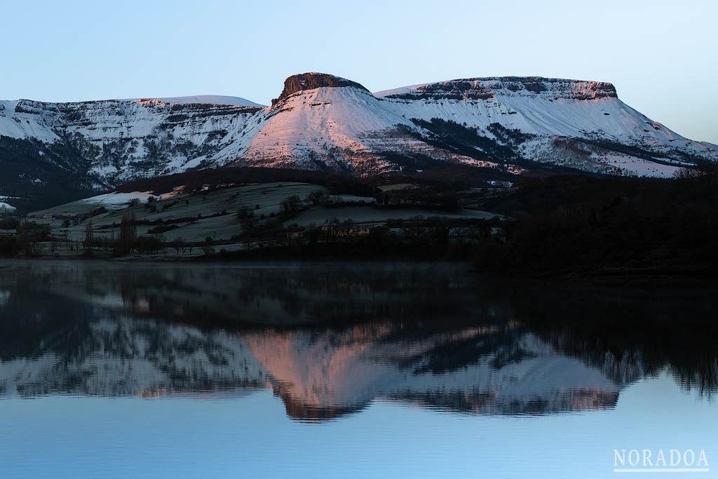 La sierra Salvada nevada reflejada en embalse de Maroño