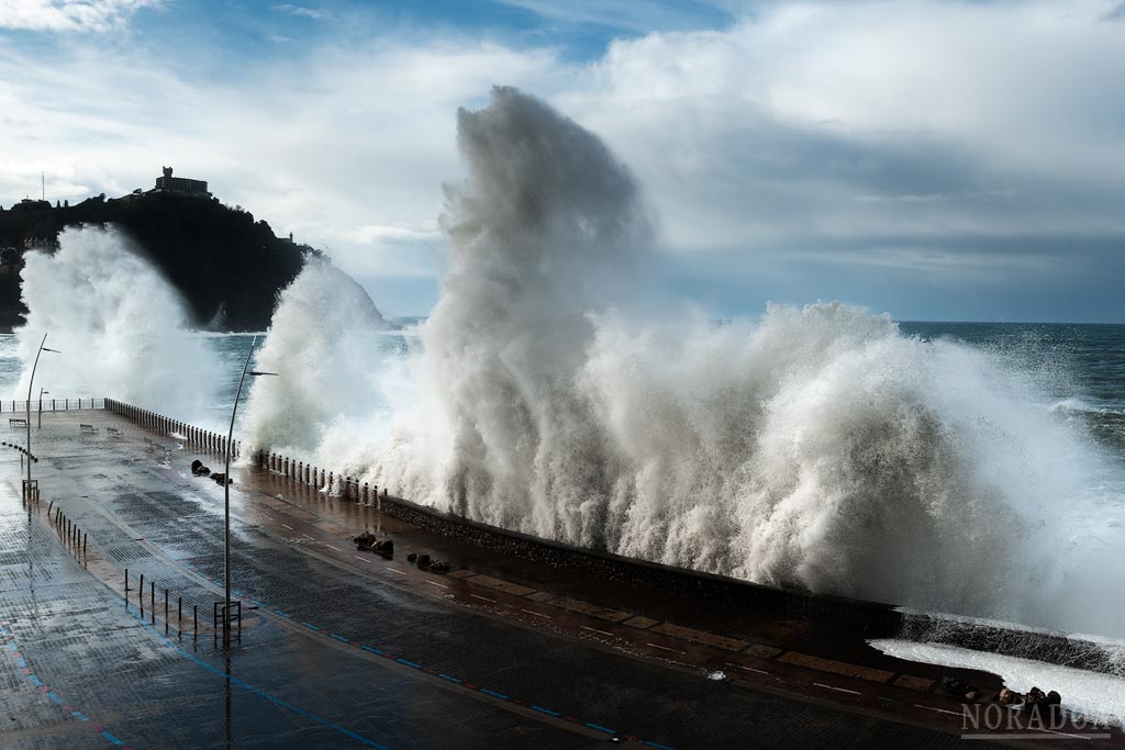 Olas rompiendo en el Paseo Nuevo con el monte Igueldo de fondo