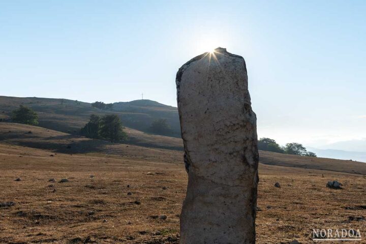 Menhir de Atau con la Cruz de Mirutegi de fondo